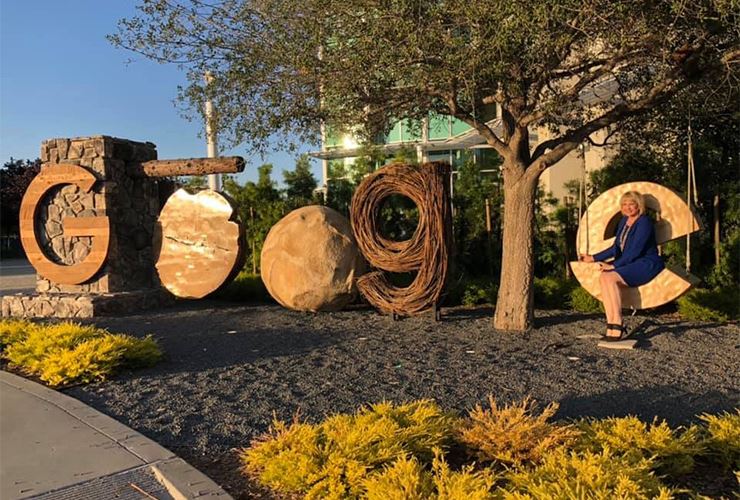 Catherine Monson poses outside of wooden letters spelling out GOOGLE